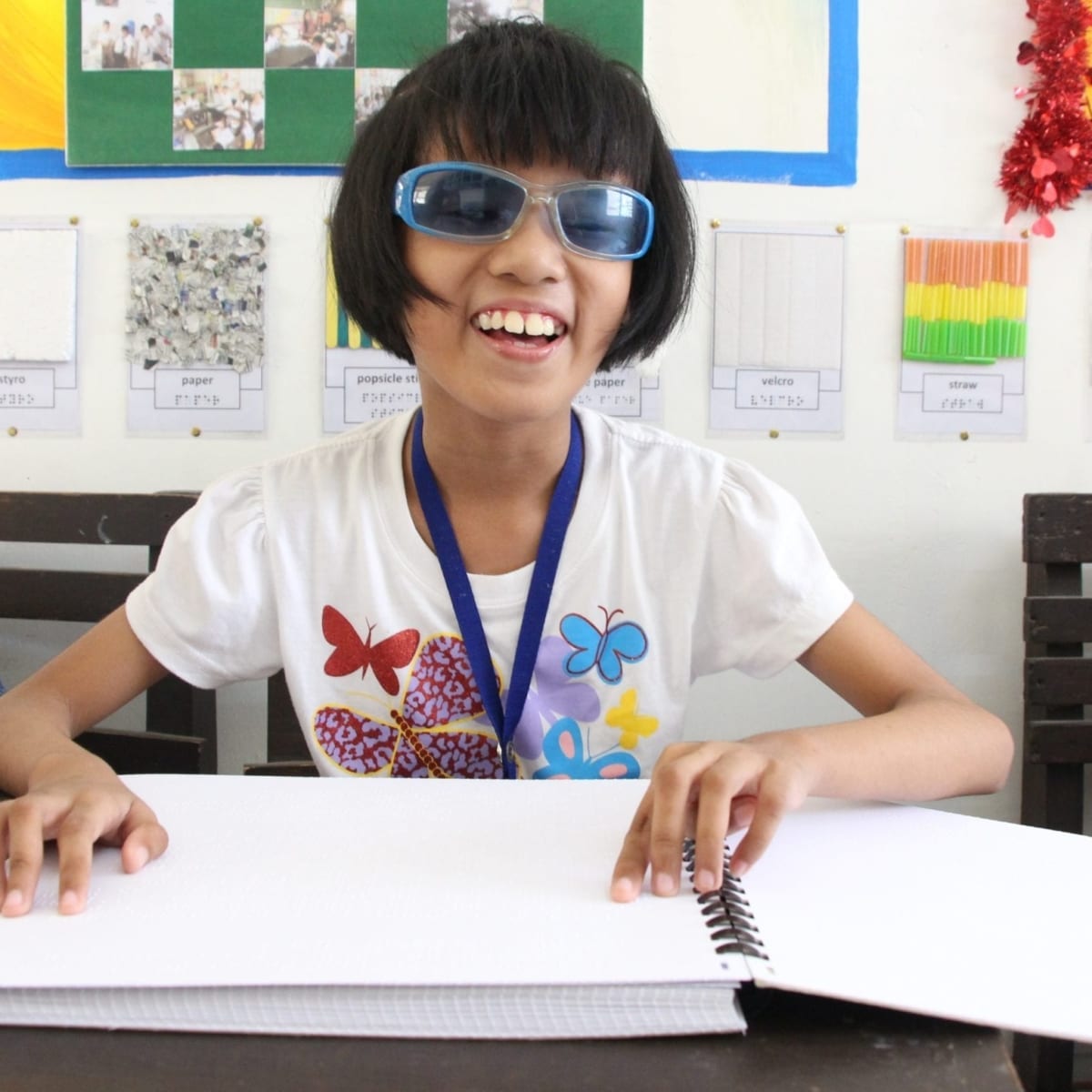 Alexa reads her braille books made by the teacher.