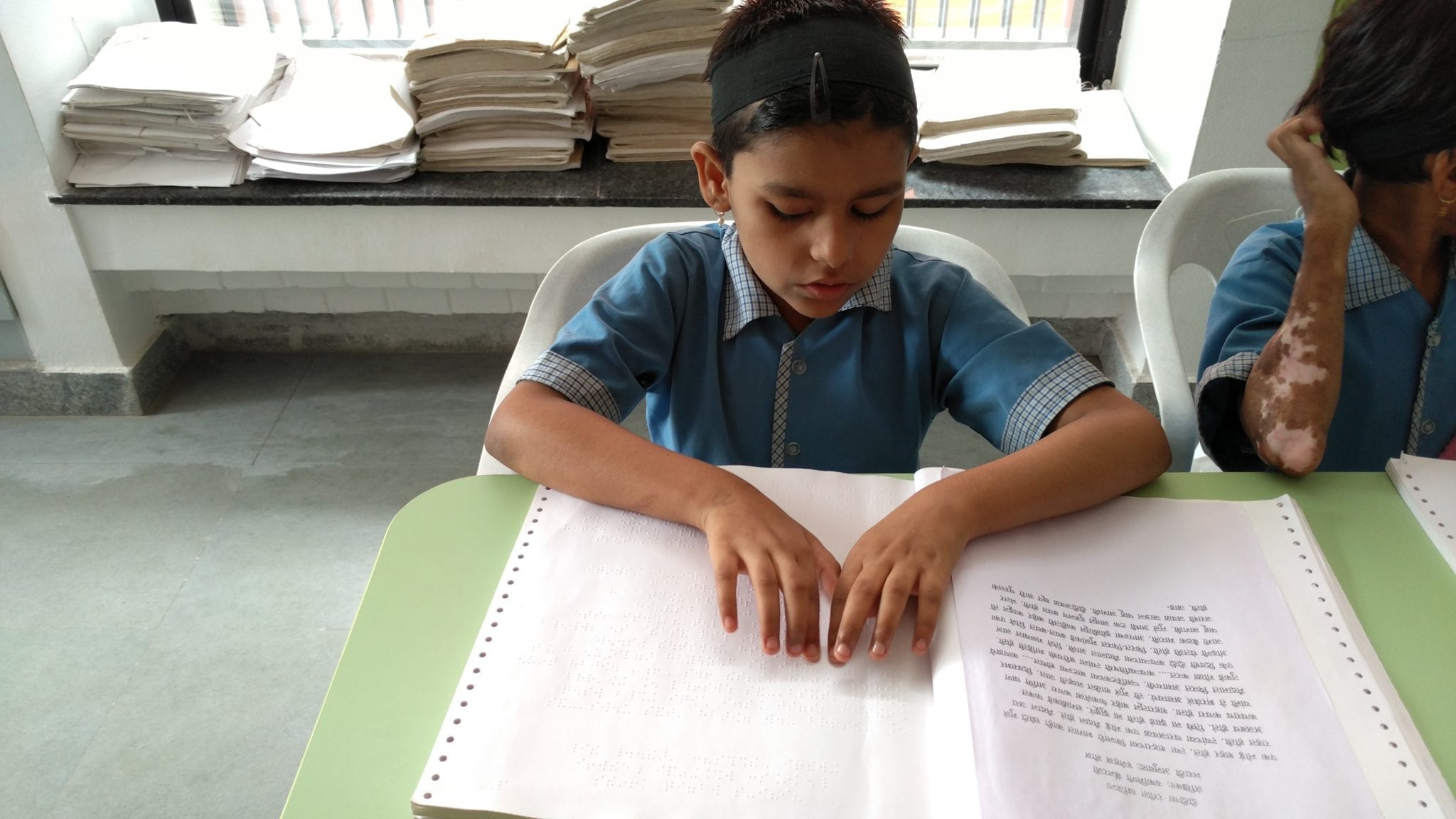 A boy reads a braille book.