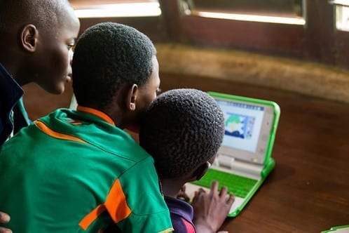 Three Zambian children using laptop.