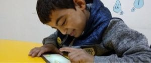 A young boy in Jordan test one of the EduApp4Syria games on a smartphone