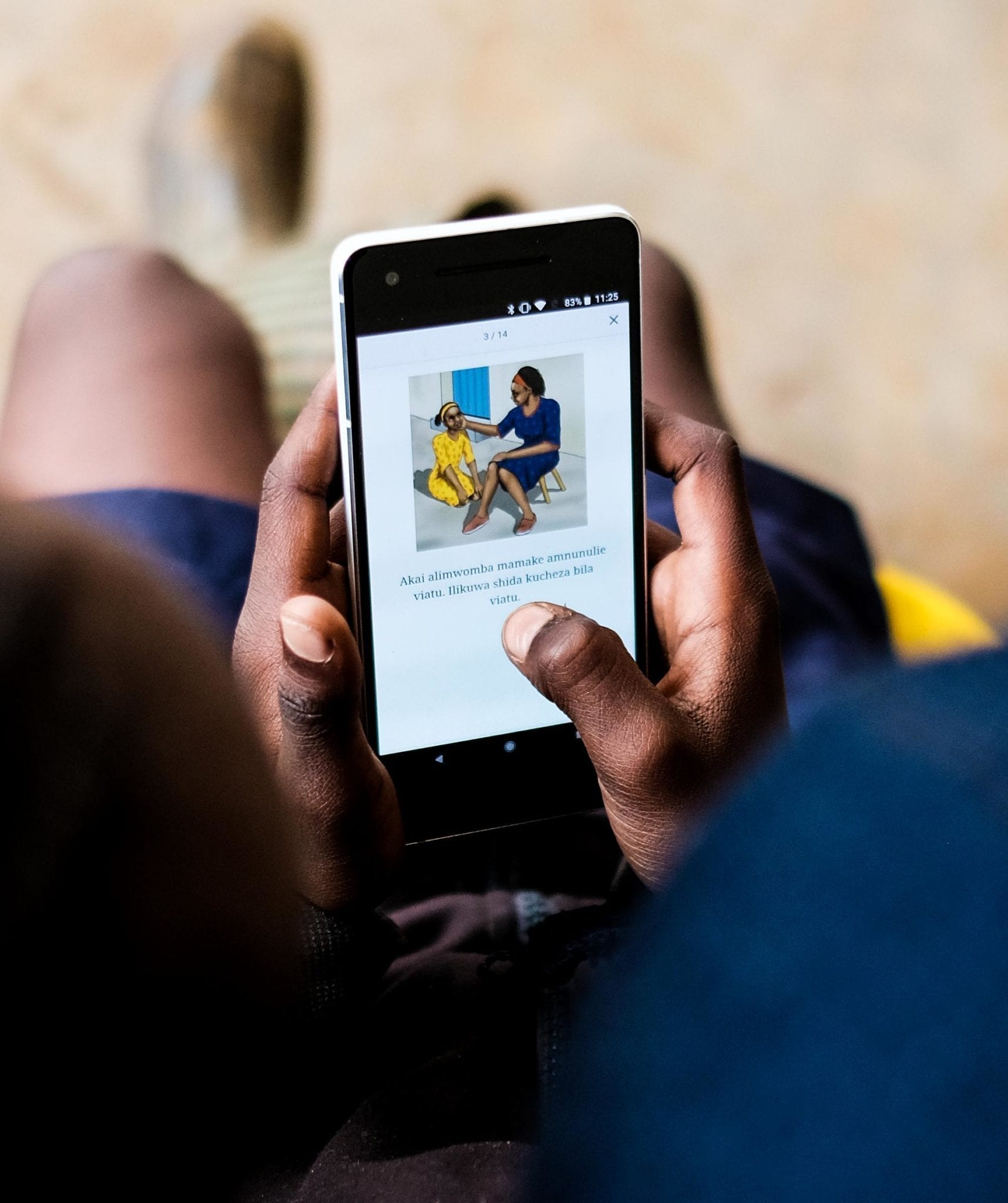A child reads a book from the Global Digital Library on a smartphone.