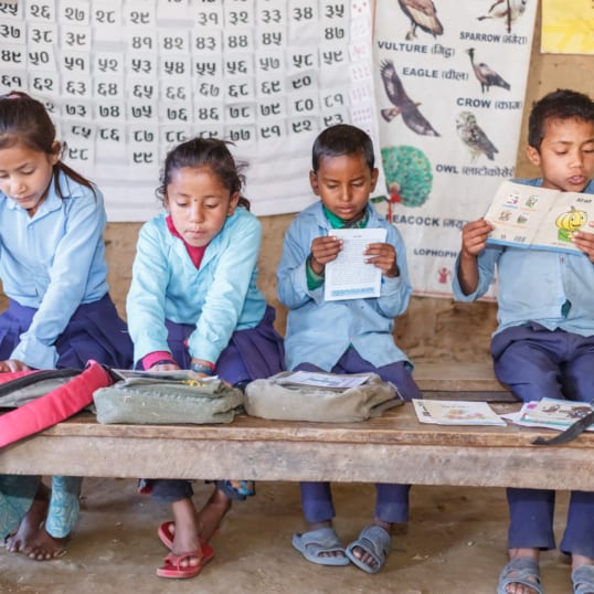 Children in Nepal read books provided through World Education, Inc.