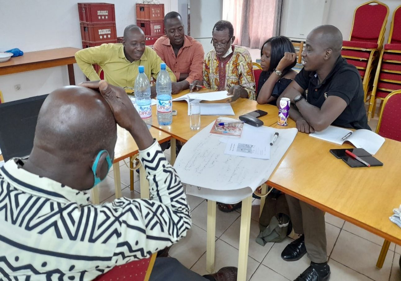 Mamara writers Lazard Daou, Jérémie Daou, Jérémie Coulibaly, Roda Daou and Elam Daou and their language facilitator Dr Kanchi Goita (left, seen from the back) discuss their work as a group. Photo Credit: Marian Hagg